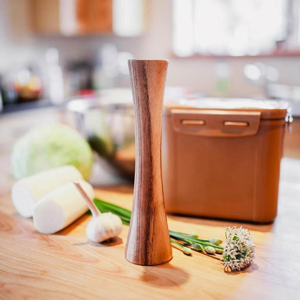 Pilon en bois pour fermentation avec contenu à fermentation et légumes