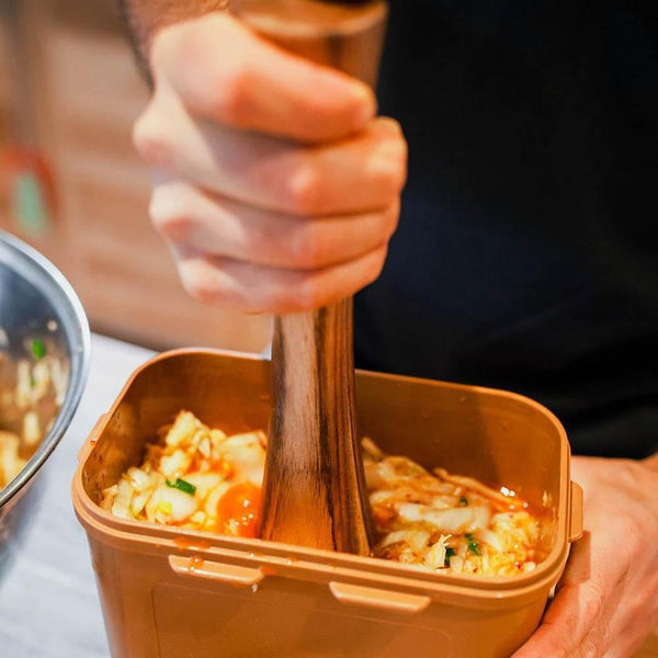 Pilon de fermentation utilisé pour compresser des légumes dans un contenant de fermentation